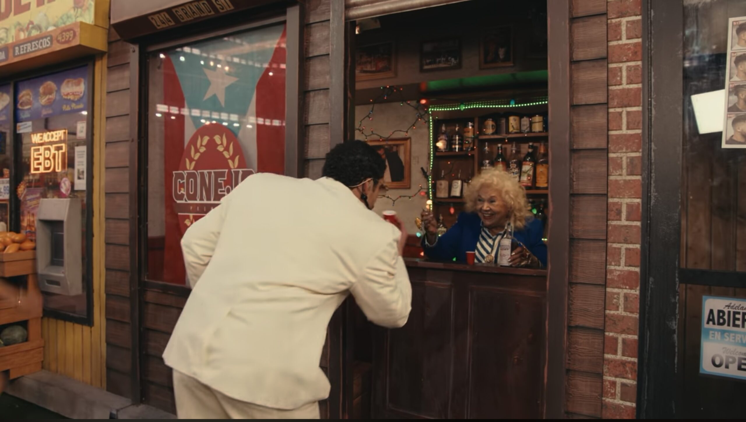Toñita sirve un shot a Bad Bunny en la réplica del Caribbean Social Club durante el show de medio tiempo del Super Bowl LX